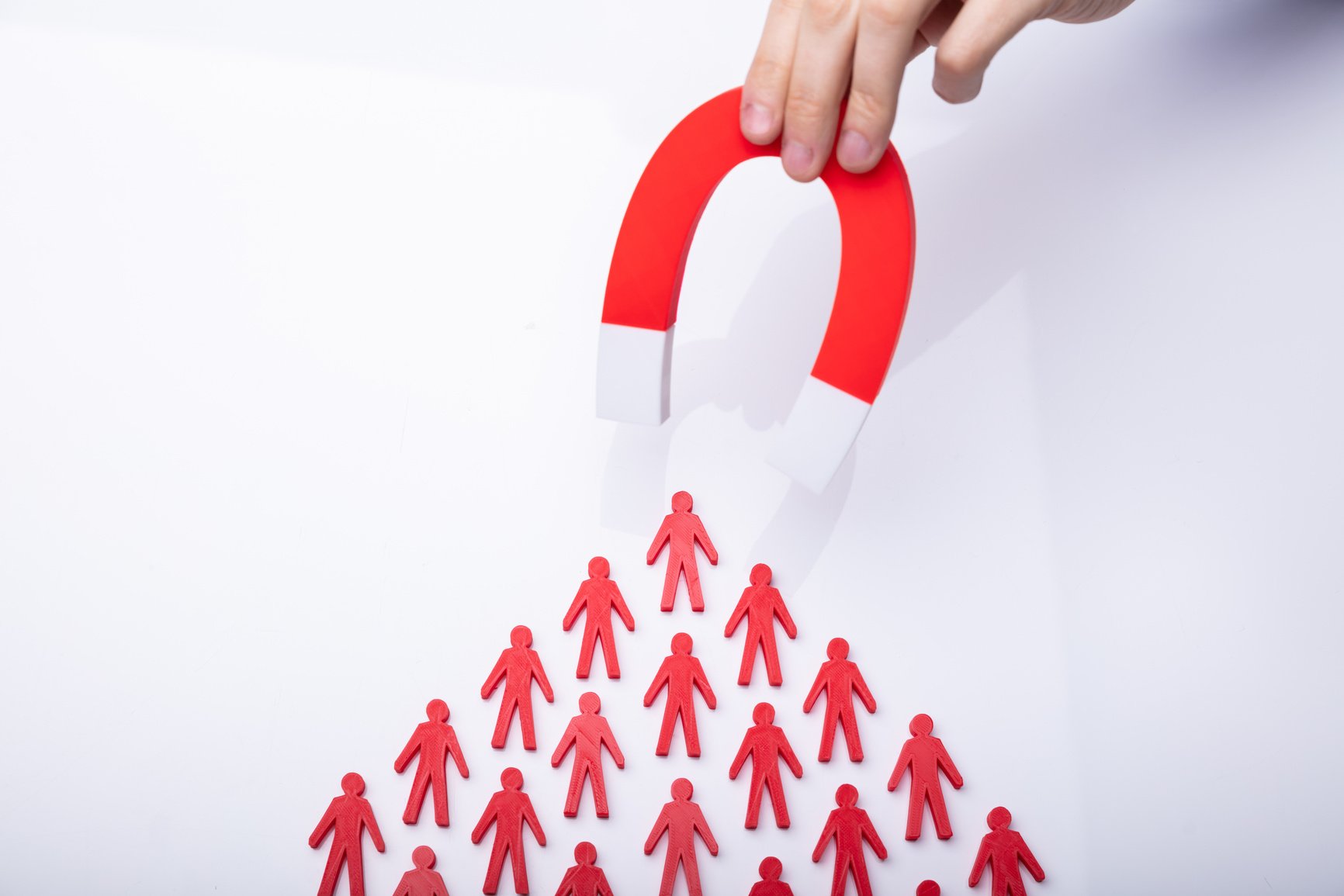 Businessman Attracting Red Team With Horseshoe Magnet